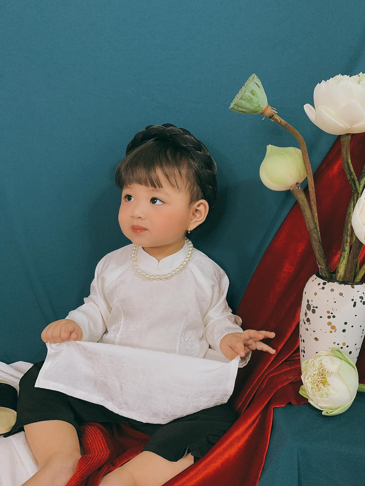 Bé gái trong bộ ảnh Tết dưới đây cũng không ngoại lệ khi được mẹ cho diện áo dài và mấn đội đầu, guốc gỗ chuẩn "người con gái Việt Nam" để chụp ảnh.