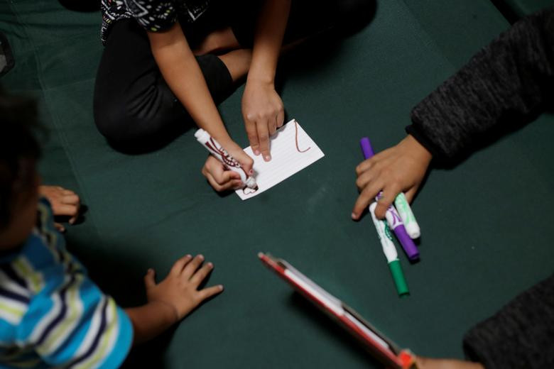 Những em nhỏ nhập cư học vẽ trong nơi ở tạm thời tại khu vực biên giới Mỹ-Mexico.