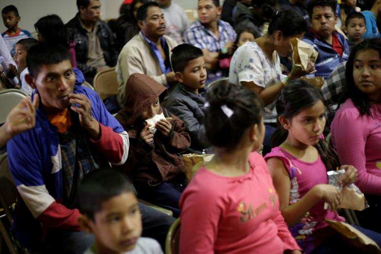 Những đứa trẻ ăn bánh sandwich sau khi tới nhà thờ Vino Nuevo ngày 23/4.