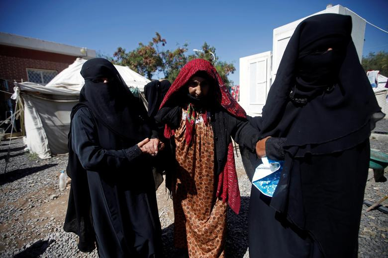 Bà Fatimah Saleh được người thân dìu đi tại bệnh viện al-Sabeen hôm 28/3.