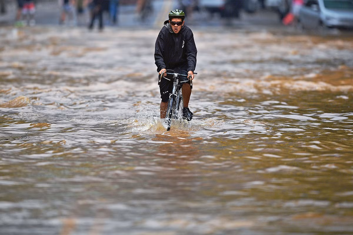 Một người đạp xe qua con đường ngập lụt ở thành phố Rio de Janeiro.