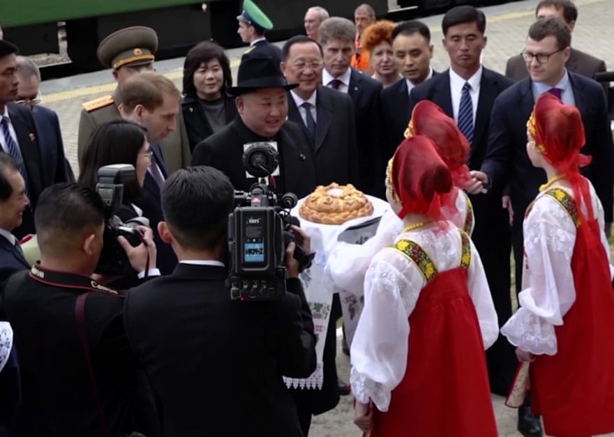 Ông Kim Jong-un được chào đón nồng nhiệt với hoa, bánh mỳ và muối sau khi đoàn tàu chở ông tới nhà ga Khasan. Ảnh: The Guardian.