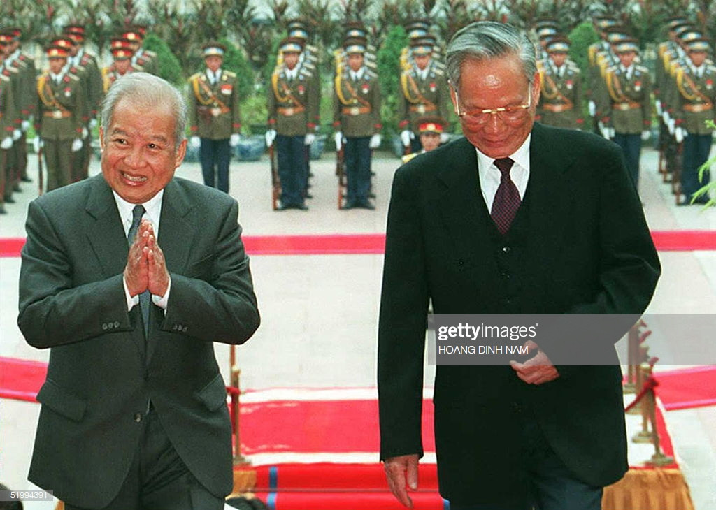 Quốc vương Campuchia Norodom Sihanouk gửi lời chào khi ông và Chủ tịch nước Việt Nam Lê Đức Anh bước vào Phủ Chủ tịch trong buổi lễ đón được tổ chức vào ngày 14/12/1995 tại Hà Nội khi Quốc vương có chuyến thăm chính thức 3 ngày tại Việt Nam. Ảnh: Getty.