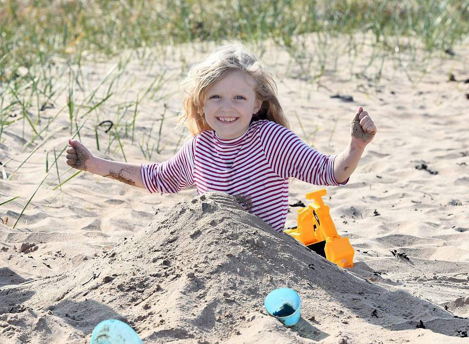 Bé gái chơi đùa ở bãi biển Berwick, Northumberland.
