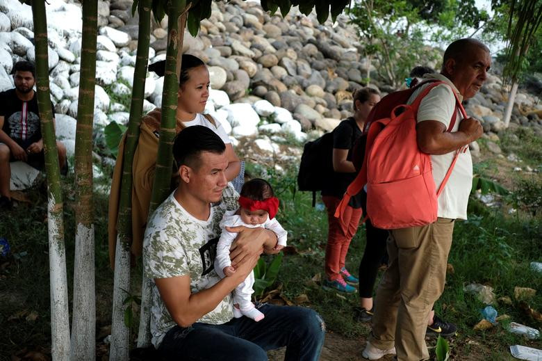 Một gia đình di dân đến từ El Salvador và các di dân Cuba nghỉ ngơi sau khi vượt qua sông Suchiate từ Tecun Uman, Guatemala, tới Ciudad Hidalgo, Mexico, ngày 7/4, trước khi tiếp tục hành trình tới Mỹ.