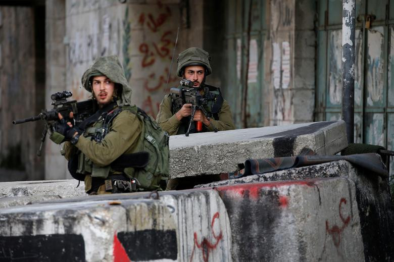 Các binh sĩ Israel cầm vũ khí khi tham gia trấn áp những người biểu tình Palestine ở Hebron, ngày 29/3.