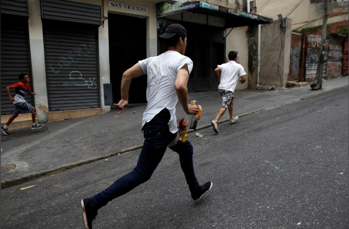 Một số người biểu tình tháo chạy trên đường phố Caracas.