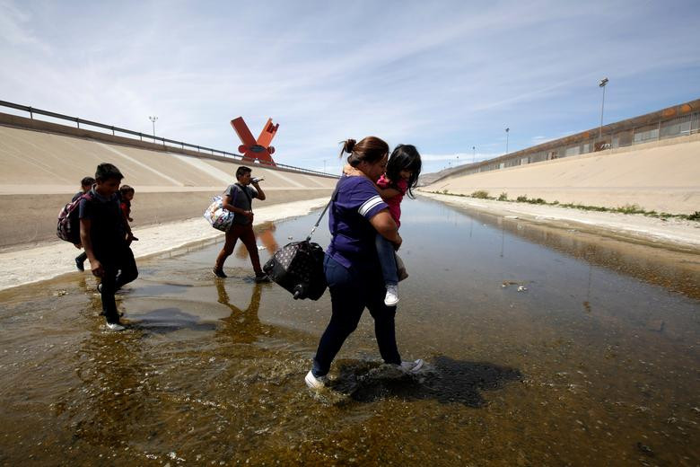 Các di dân Trung Mỹ lội qua sông Rio Bravo ở El Paso, bang Texas, Mỹ, nhìn từ Ciudad Juarez ngày 2/4.