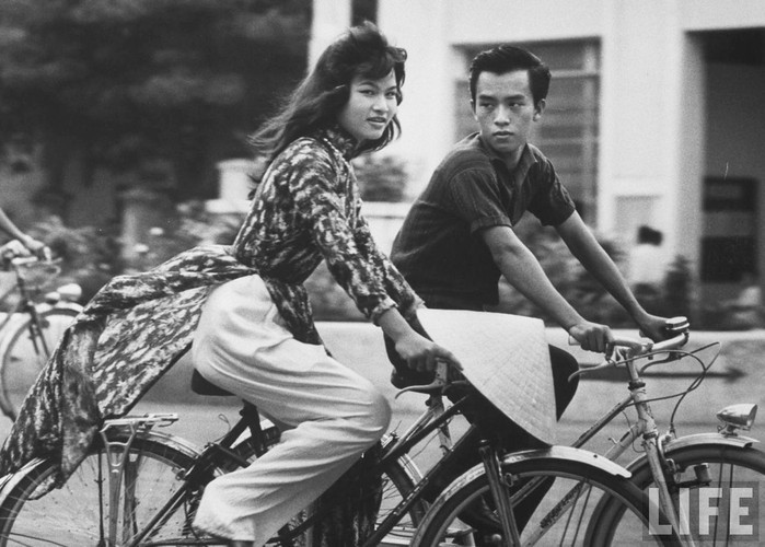 Người đẹp áo dài hoa đạp xe cùng bạn trai. Ảnh: John Dominis / Life.