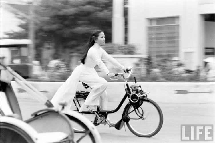 Tiểu thư Huế vi vu trên xe đạp gắn máy. Ảnh: John Dominis / Life.