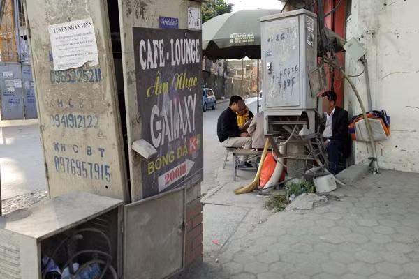 Người dân vẫn thản nhiên bán hàng nước, ngồi ngay dưới chân cột điện khi khoảng cách an toàn với điện chưa đầy 0,5m.