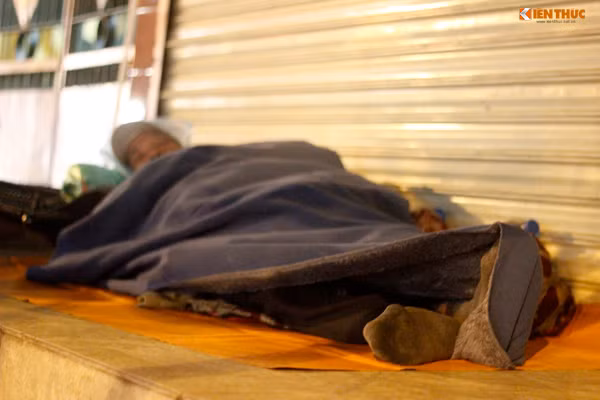 Đôi tất đã cũ kỹ vẫn còn in rõ vết bẩn giúp người đàn ông vô gia cư giữ ấm đôi bàn chân.