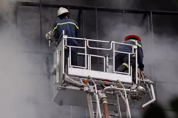 Khói từ bên trong dãy nhà hàng, quán karaoke bị cháy liên tục phun ra ngoài bay mù mịt.