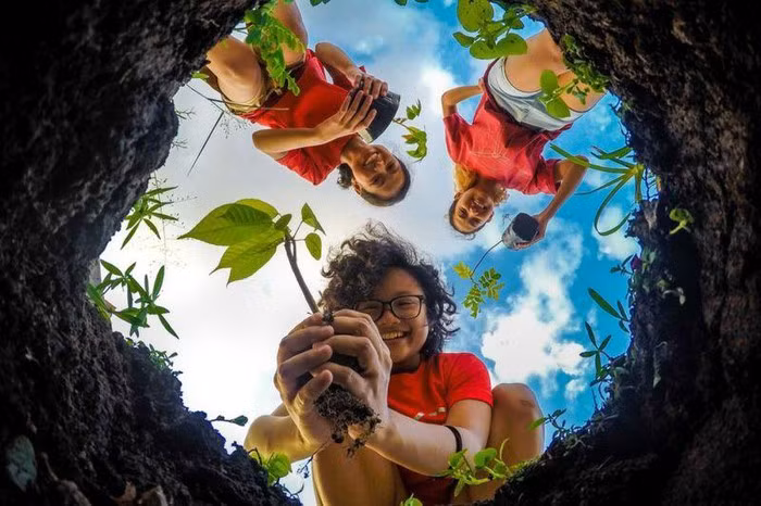 Trong bức ảnh này 3 tình nguyên viên đang rất vui vẻ và mãn nguyện trong hoạt động trồng cây, phủ xanh đất trống bảo vệ môi trường.