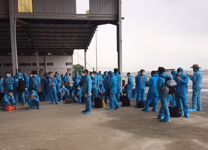 Sau khi làm các thủ tục phòng dịch, mặc đồ bảo hộ tất cả người lao động lên máy bay chuẩn bị về nước.