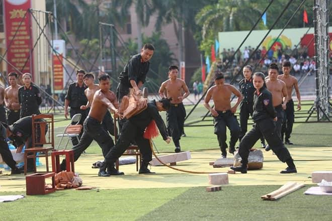 Dùng búa đập gạch trên lưng nữ chiến sĩ Cảnh sát cơ động. (Ảnh: C500)