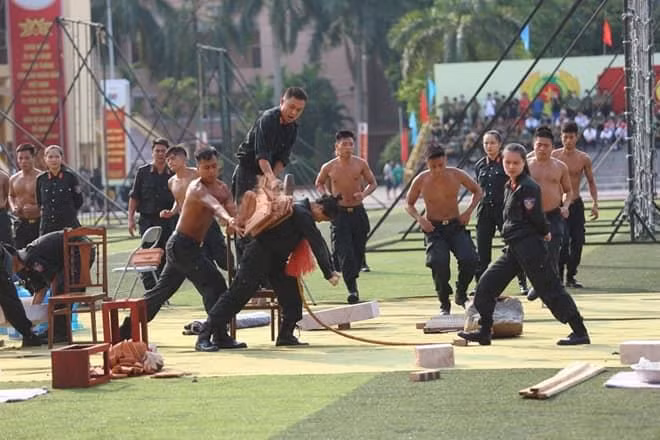 Dùng búa đập gạch trên lưng nữ chiến sĩ Cảnh sát cơ động. (Ảnh: C500)