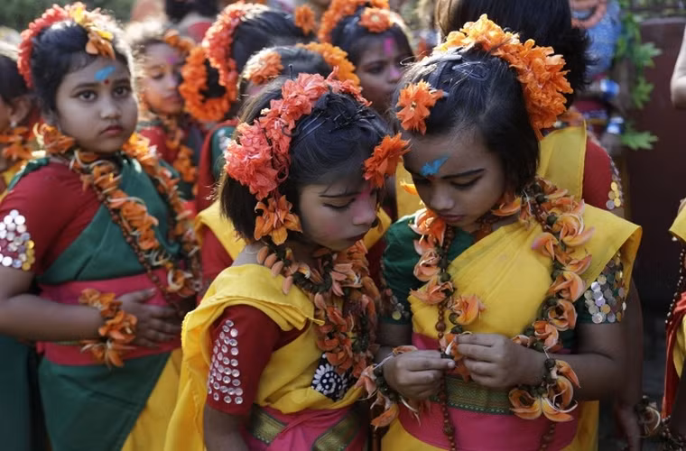 Những cô bé Ấn Độ cùng vòng hoa đeo trên đầu và cổ đang chờ đợi để biểu diễn trong lễ hội màu sắc Holi ở thành phố Kolkata, Ấn Độ.