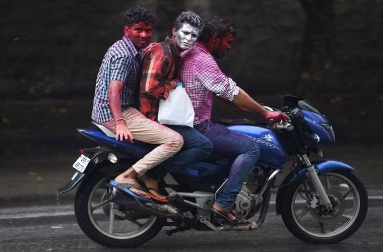 3 thanh niên Ấn Độ di chuyển trên chiếc xe máy trong thời gian diễn ra lễ hội tại thành phố Hyderabad, Ấn Độ.