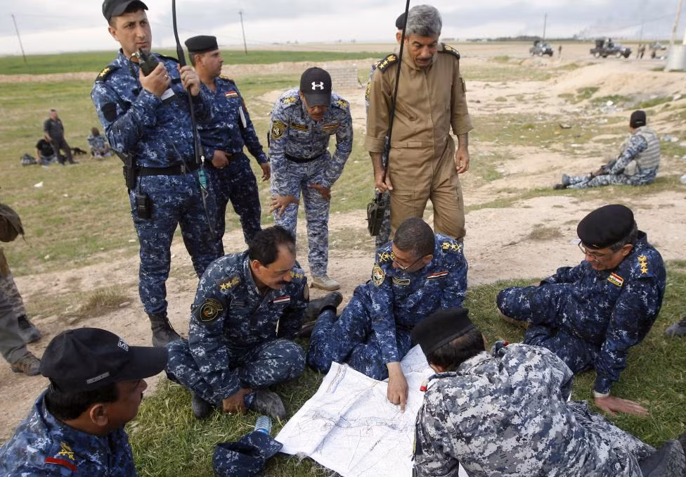 Quan chức quân đội Iraq nghiên cứu chiến lược trên tấm bản đồ ở thị trấn ngoại ô al-Alam ngày 8/3/3015.