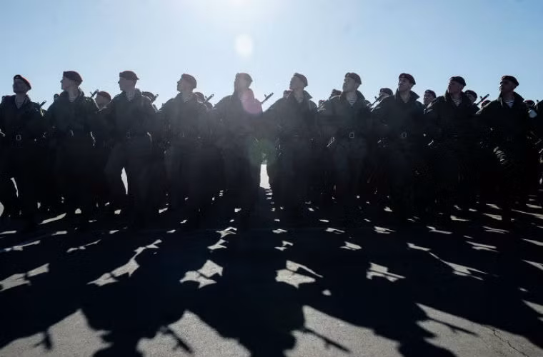 Binh lính thực hành tư thế đứng nghiêm với súng trên vai.