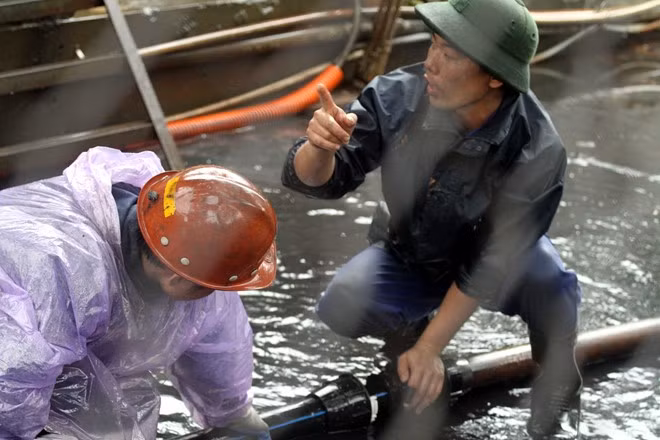 Công nhân đấu nối đường ống, bơm nước dưới đường lò bị ngập.