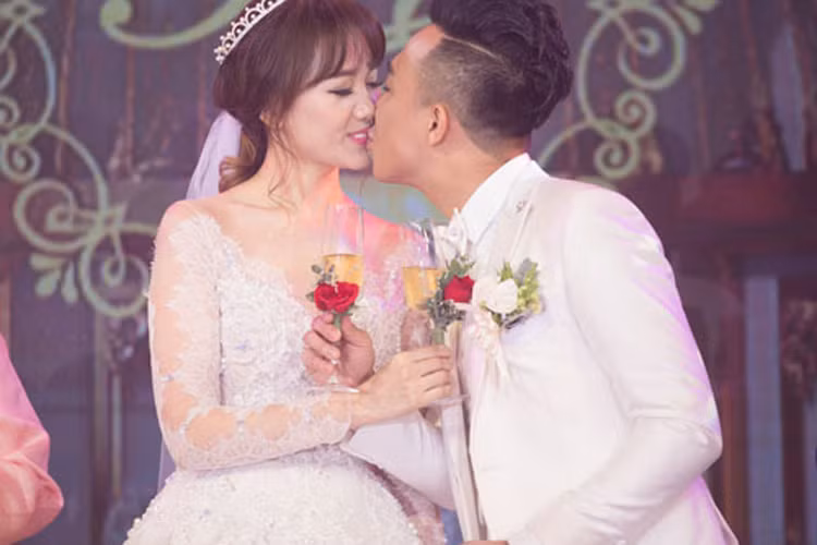 Trấn Thành - Hari Won hôn nhau ngọt ngào khi cùng uống rượu giao bôi trong đám cưới cổ tích. (Ảnh: Dân Việt)
