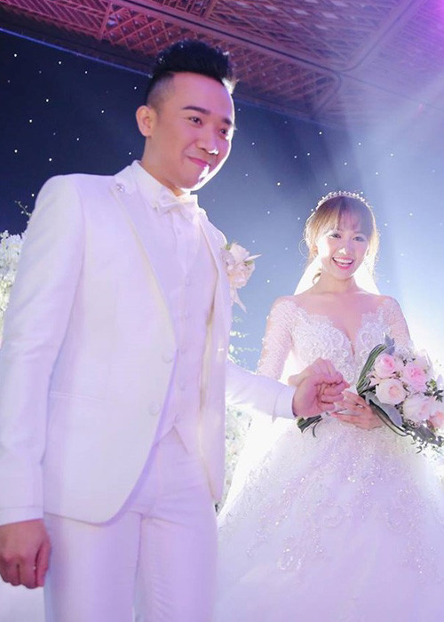 Hari Won - Trấn Thành tay trong tay hạnh phúc bước vào lễ đường. (Ảnh: Zing)