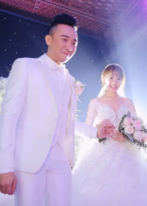 Hari Won - Trấn Thành tay trong tay hạnh phúc bước vào lễ đường. (Ảnh: Zing)