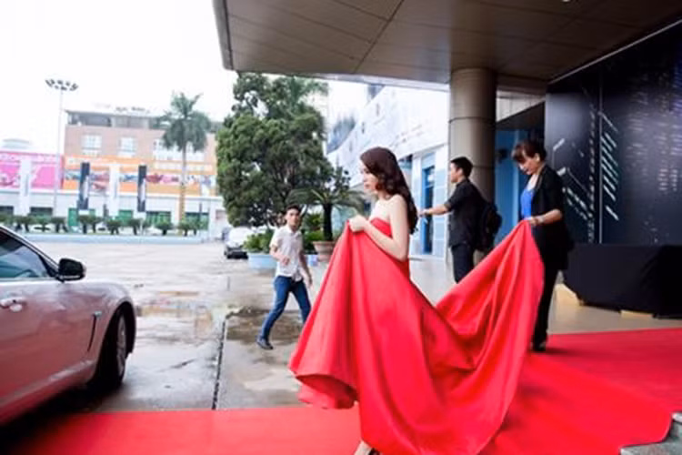 Sau hình ảnh để mẹ đẩy hành lý tại sân bay, Kỳ Duyên tiếp tục khiến cư dân mạng không hài lòng vì không ít lần để mẹ phải chăm sóc thái quá từ cúi gập người để chỉnh váy đến gắp thức ăn tại sự kiện. (Ảnh: Sân khấu điện ảnh)