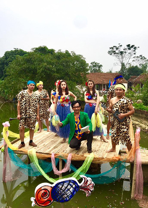 Nghệ sĩ Quang Tèo gây tò mò khi cầm đũa chỉ huy dàn nhạc bên cạnh các vũ công và nhạc công trong trang phục thổ dân. (Ảnh: Facebook nhân vật)