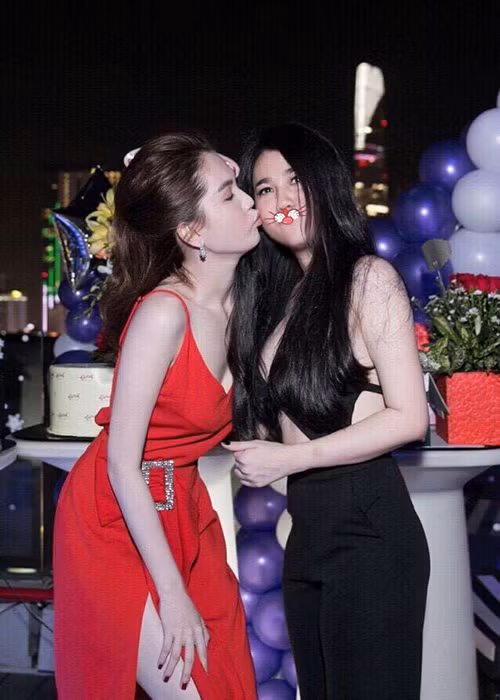Nữ diễn viên phim “Vòng eo 56” chu môi hôn má người chị gái thân thiết. (Ảnh: Facebook chị gái Ngọc Trinh)