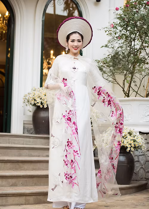 Người đẹp sinh năm 1993 bước đi duyên dáng, uyển chuyển với tà áo dài tung bay trong sự kiện.