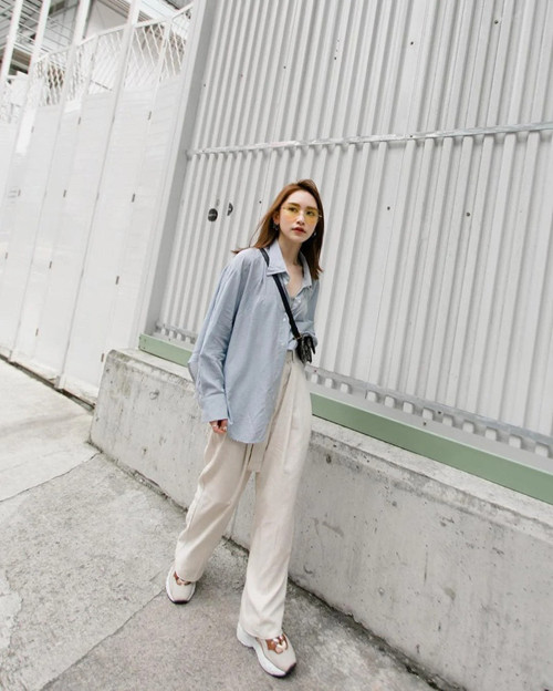 Một ưu điểm khác của áo sơ mi oversize là không kén dáng, giúp người mặc che khuyết điểm cơ thể. So với thiết kế ôm sát, mẫu áo oversize khiến người mặc trông gầy hơn. Nhìn từ xa, cô gái gầy trông càng mỏng manh dưới lớp áo thùng thình.