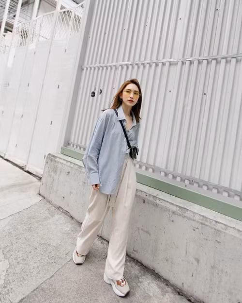 Một ưu điểm khác của áo sơ mi oversize là không kén dáng, giúp người mặc che khuyết điểm cơ thể. So với thiết kế ôm sát, mẫu áo oversize khiến người mặc trông gầy hơn. Nhìn từ xa, cô gái gầy trông càng mỏng manh dưới lớp áo thùng thình.