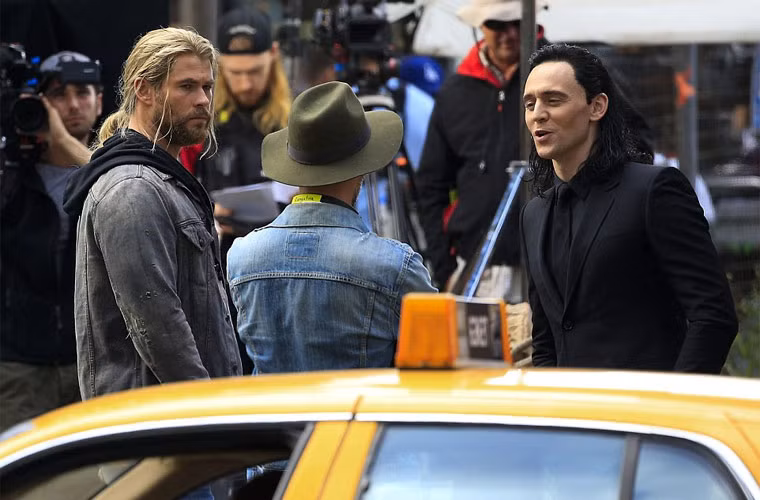 Với khuôn mặt trang điểm đậm cùng mái tóc đen dài, khó có thể nhận ra Tom Hiddleston nếu anh không đi cùng bạn diễn Chris Hemsworth.