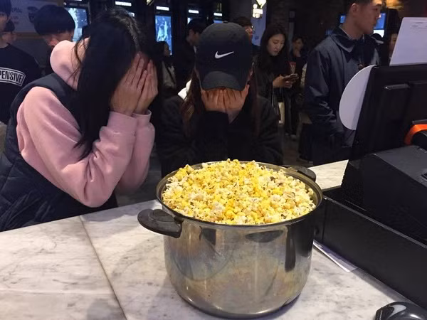 Nhiều người không ngần ngại mang cả xô 20 lít đi để đựng bỏng ngô cùng với trang phục áo mưa và khẩu trang bịt kín mặt không hề liên quan tới việc xem phim