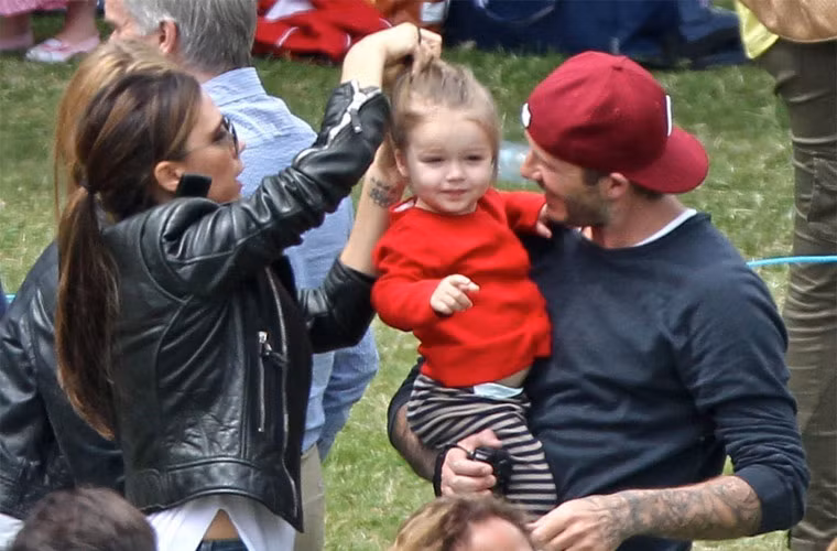 Mẹ Vic buộc lại tóc cho con gái út còn bố Beck thì bế em trên tay và trò chuyện rất vui vẻ khi tới cổ vũ anh trai Cruz trong một buổi thi đấu thể thao ở trường.