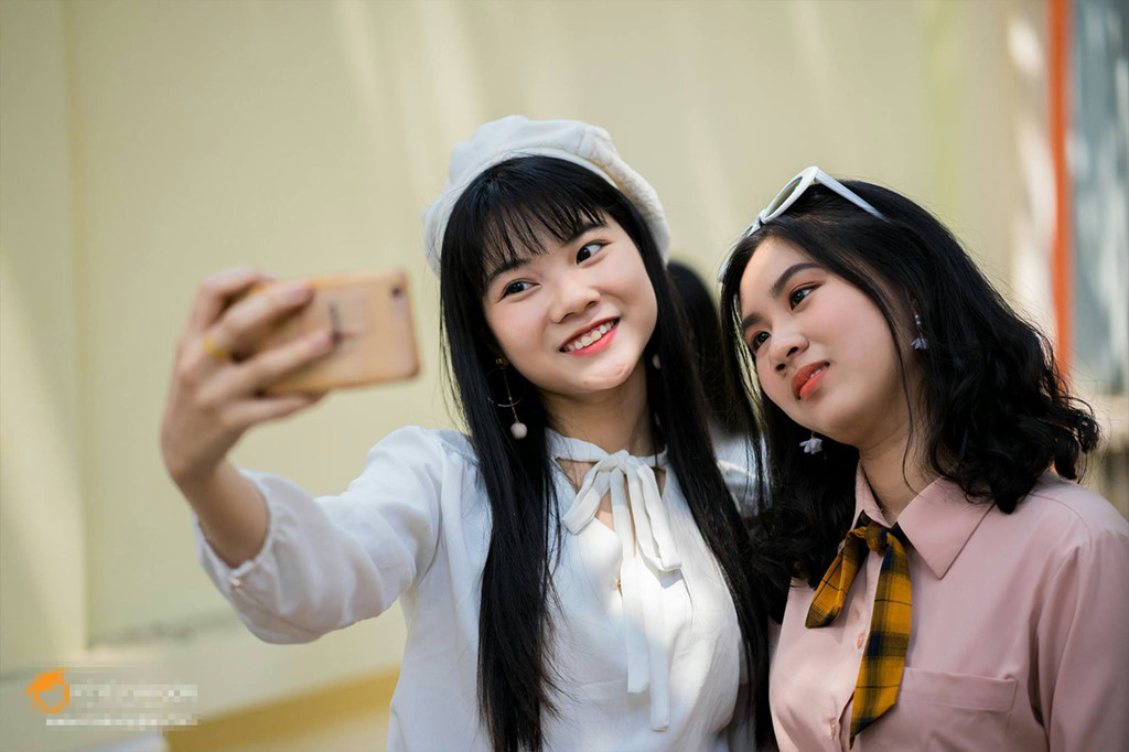 Các bạn nữ hào hứng lưu giữ khoảnh khắc thanh xuân trong trang phục áo sơ mi trắng và chân váy sẫm màu.
