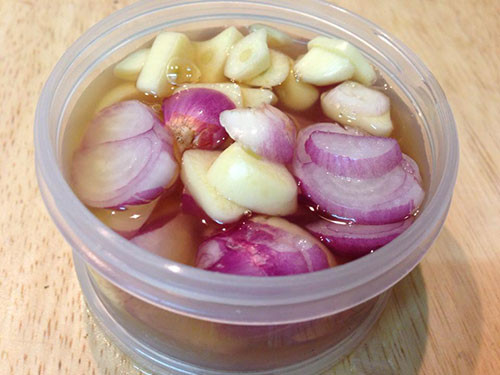 Bài thuốc trị ho, tiêu đờm cho bé bằng tỏi hành khô thái lát ngâm mật ong.