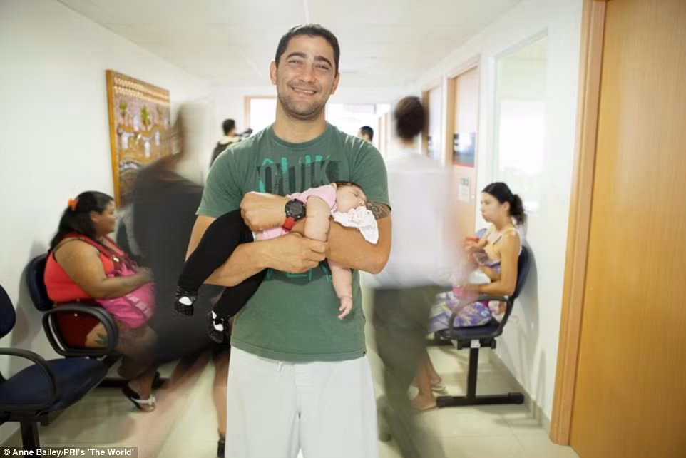 Anh Andre Guimaraes, 35 tuổi mỉm cười khi bế con gái 3 tháng tuổi Lauren de Fatima Guimaraes trong vòng tay.