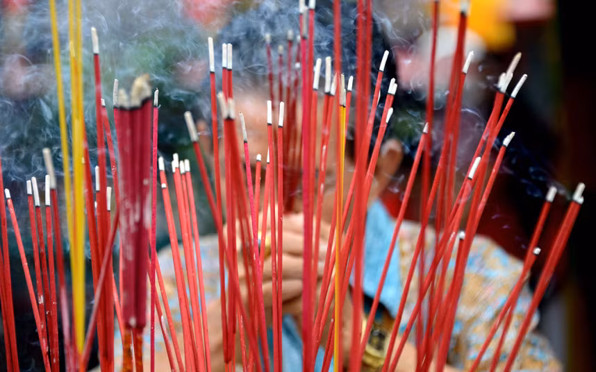 Một người đàn ông ở đảo Bali, Indonesia đang thắp nén nhang cầu nguyện vào ngày đầu tiên của năm con khỉ tại chùa Dharmayana ở Kuta, Bali.