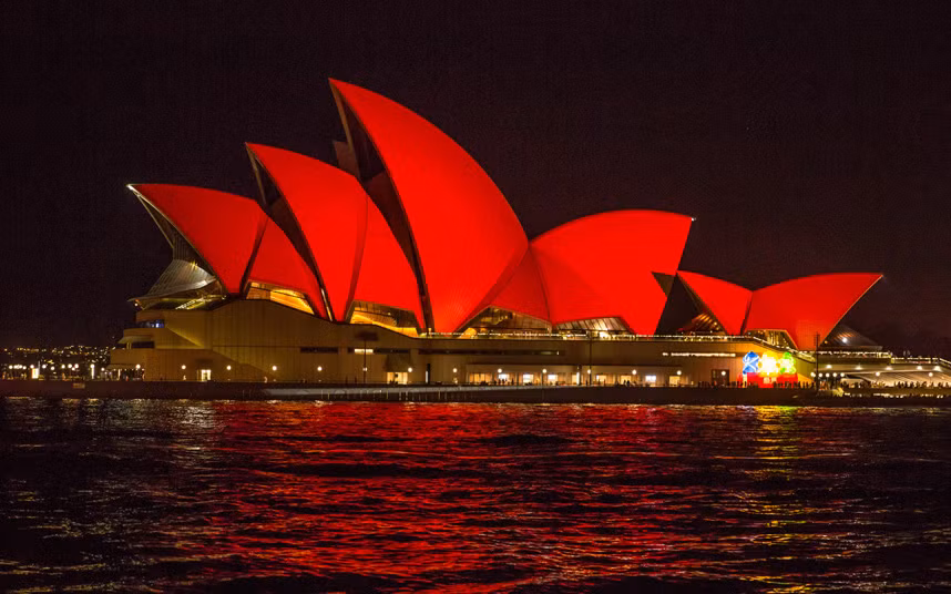Nhà hát Opera Sydney ở Australia được đổi màu ánh sáng màu đỏ để chào mừng Tết Nguyên Đán.