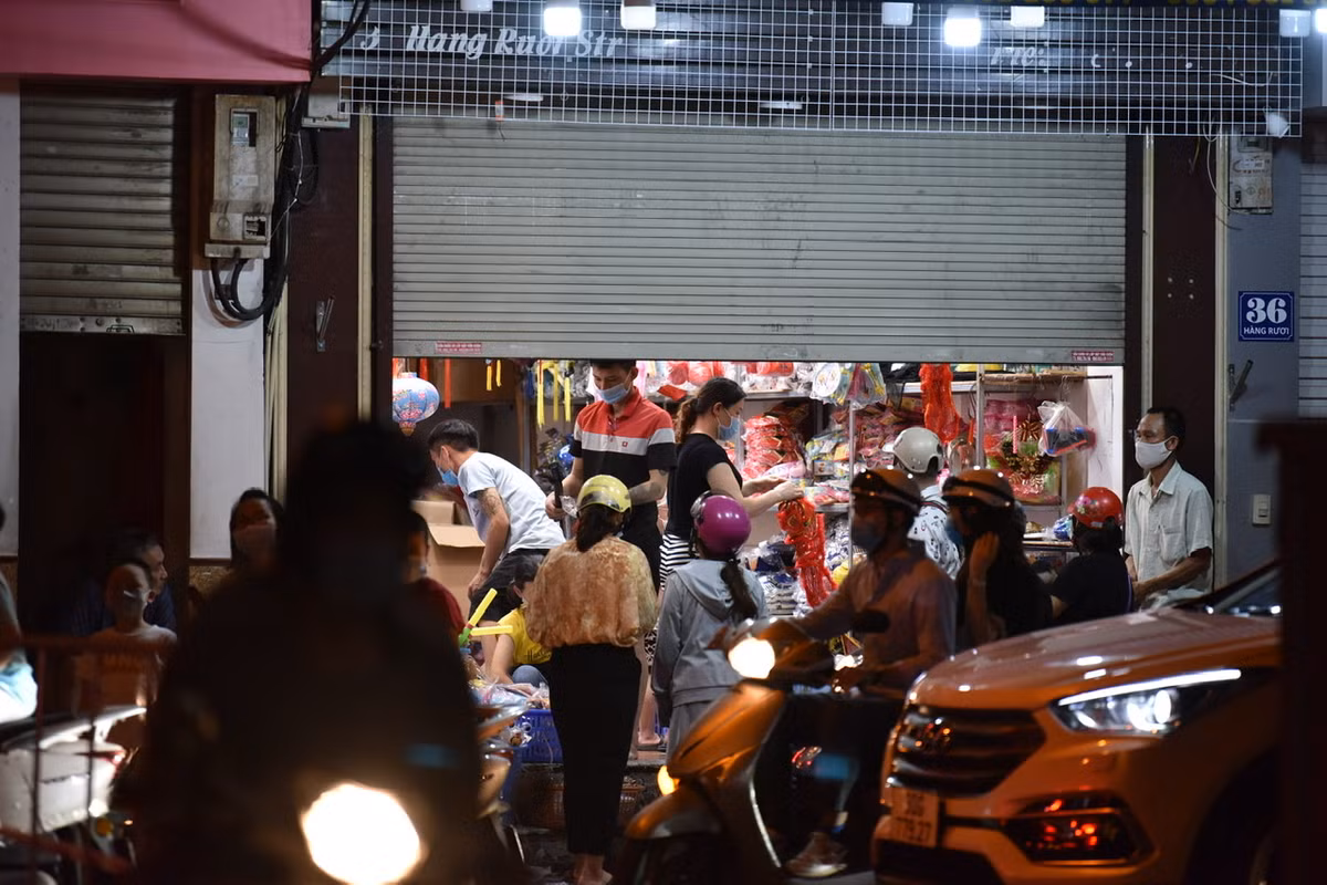 Một cửa hàng bán đồ chơi Trung Thu trên phố Hàng Rươi vẫn “nửa kín nửa hở” bán hàng cho khách.