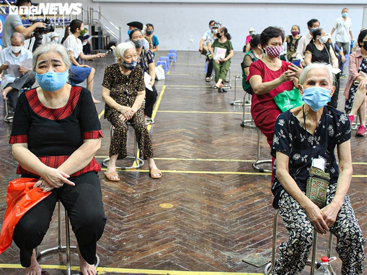 Phía bên trong Nhà thi đấu Trịnh Hoài Đức, người dân sau khi đo huyết áp, khám sàng lọc sẽ ngồi chờ đến lượt tiêm vaccine.