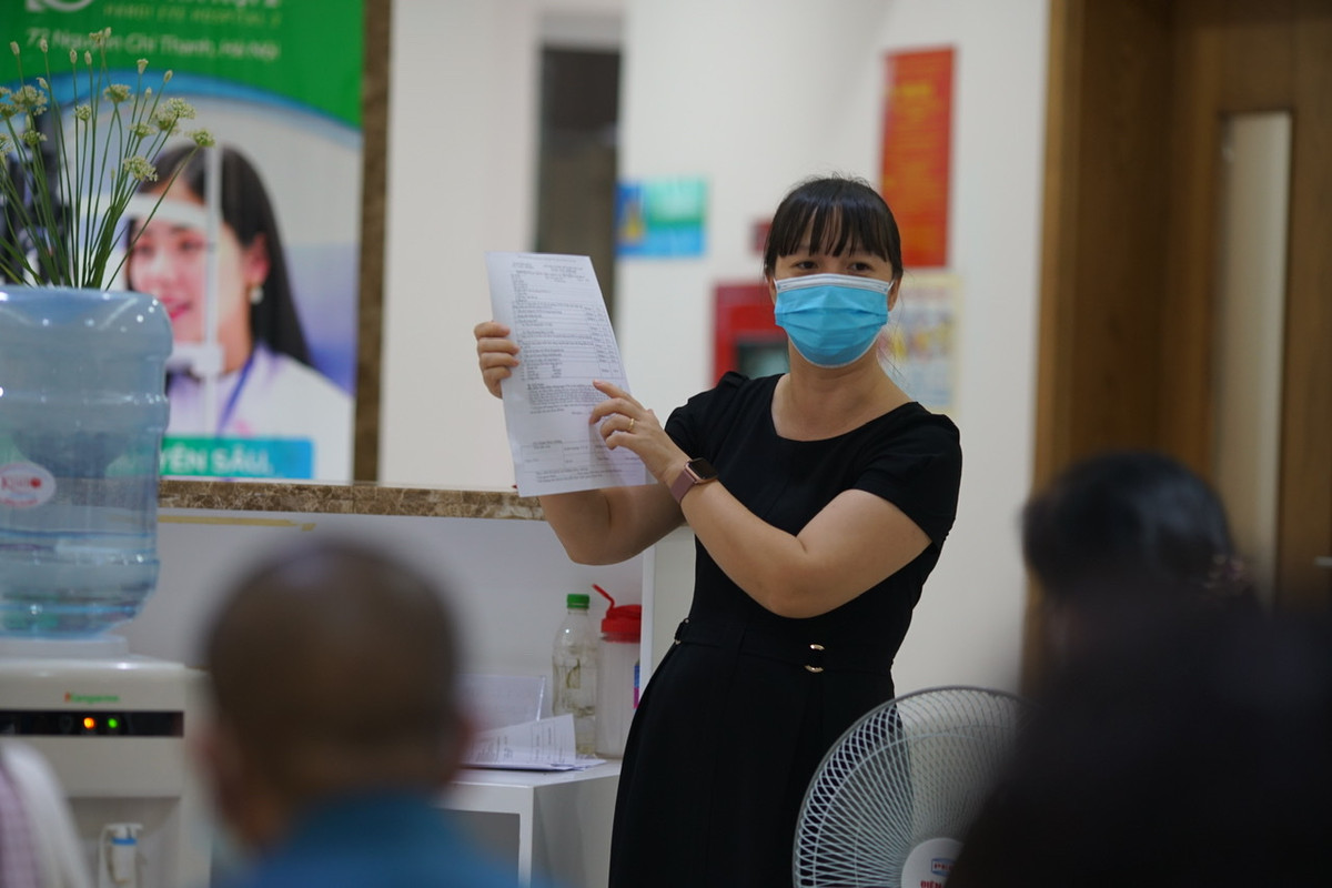 Trong lúc ngồi tại phòng chờ, Ban tổ chức tiêm đã bố trí cán bộ hướng dẫn, lưu ý người dân điền đầy đủ thông tin vào phiếu đăng ký tiêm.