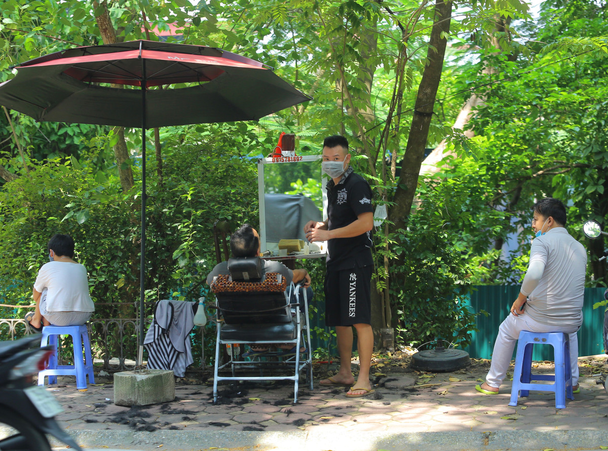 Sáng nay (21/9), hàng loạt tiệm cắt tóc vỉa hè đã mở cửa hoạt động trở lại sau 2 tháng phải nghỉ dịch COVID-19.