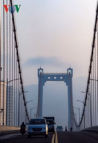 Nhiều người lưu thông trên cầu Thuận Phước bất ngờ trước làn sương mù. Phía xa là đỉnh núi Sơn Trà.