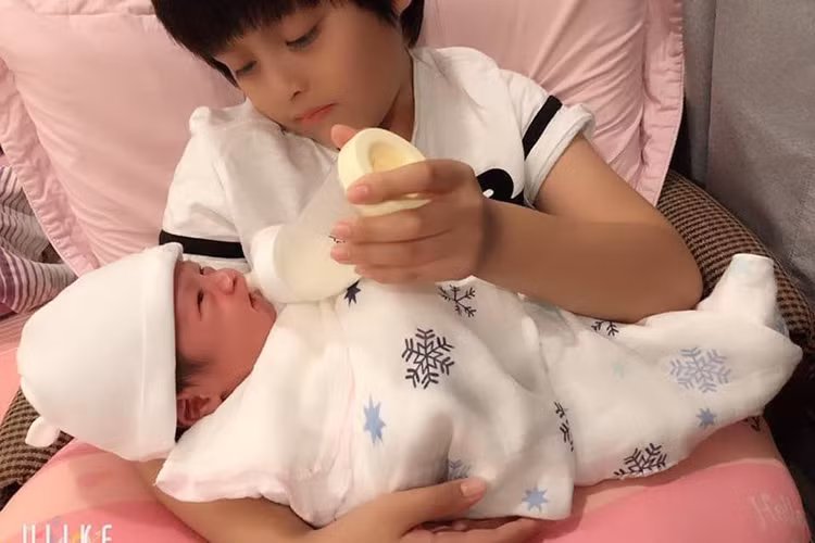 Bé Cà Phê - con trai đầu lòng của Thanh Thúy phụ giúp bố mẹ chăm em trai nhỏ.