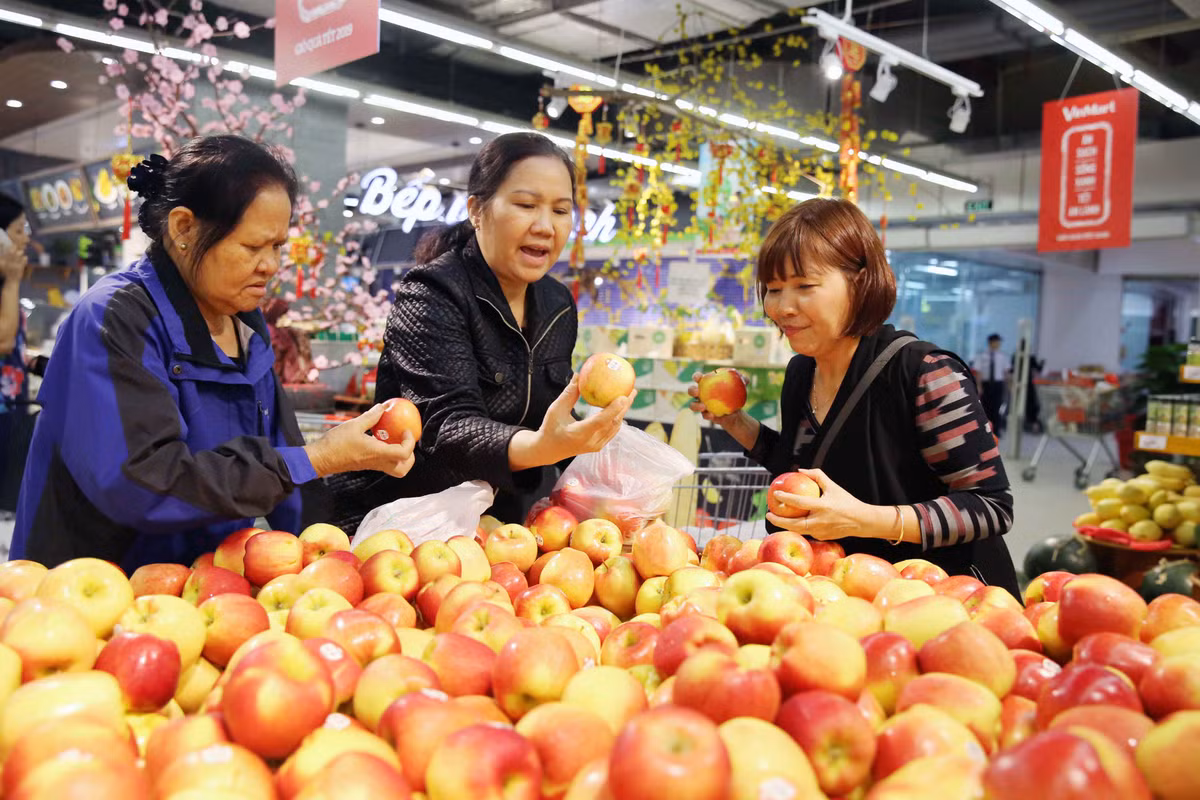 Một nhóm chị em phụ nữ hào hứng lựa những quả tươi ngon nhất về cho gia đình.